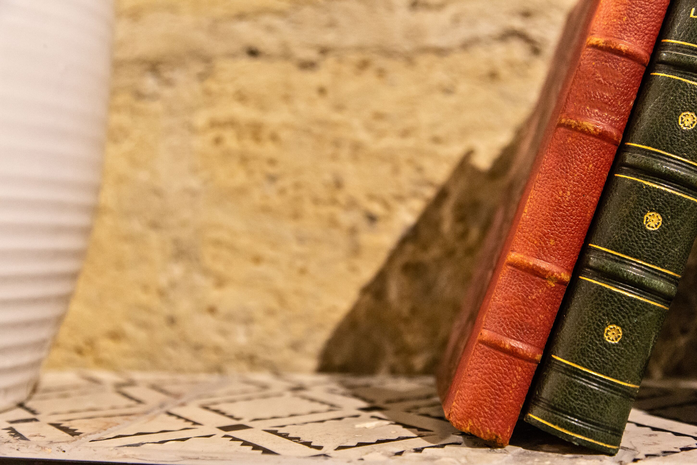 Un primo piano di due libri con cuciture gialle sui dorsi, posti su una superficie strutturata.