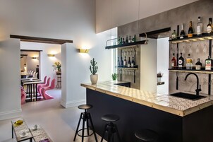 A modern kitchen with a bar area, featuring a wine rack, bar stools, and a countertop with a sink.