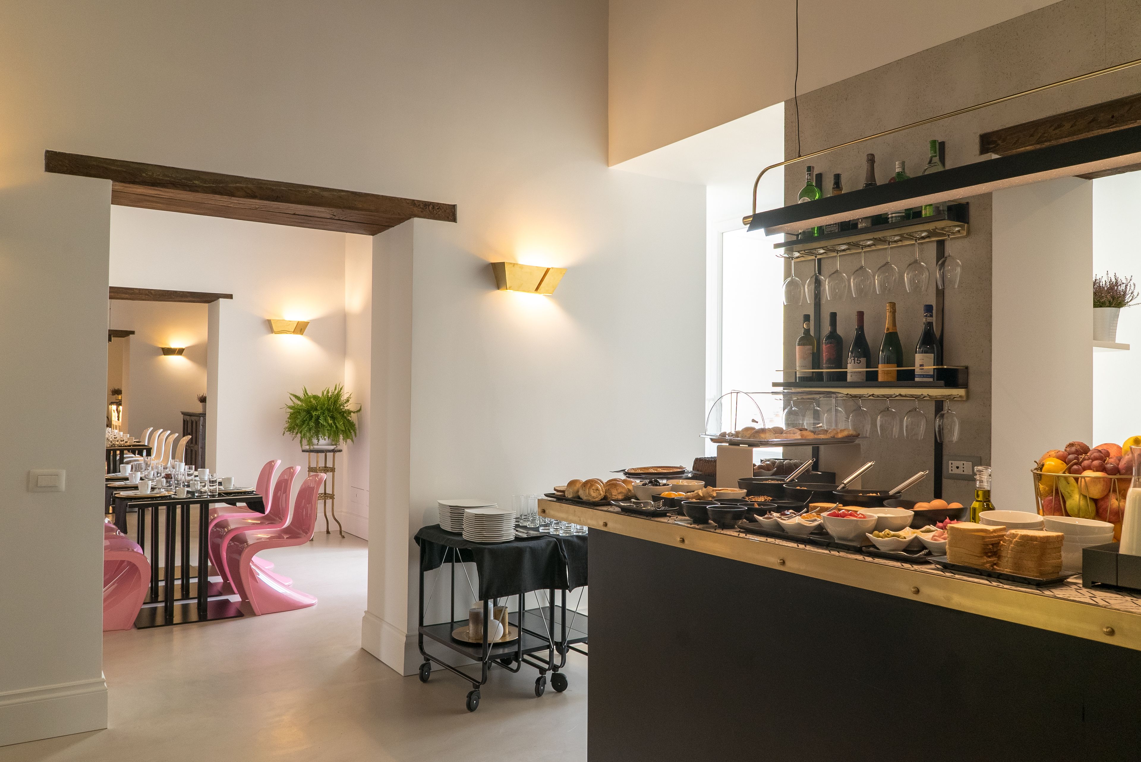 Une cuisine moderne avec un bar pour prendre le petit-déjeuner, des bouteilles de vin et une présentation de fruits.