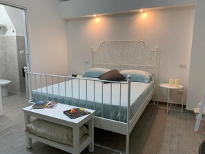 Ein Schlafzimmer mit Bett, Nachttisch und einer kleinen Nachttischlampe.