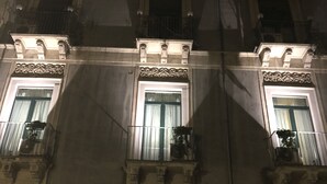 A building facade with ornate architectural details, including a sign reading "LIBRERIA del CORSO" and balconies with potted plants. - Catania House (Catania)