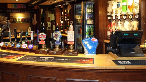 A bar counter with multiple beer taps, a Pepsi dispenser, and a digital cash register. - White Hart, Andover by Marston's Inns (Andover)