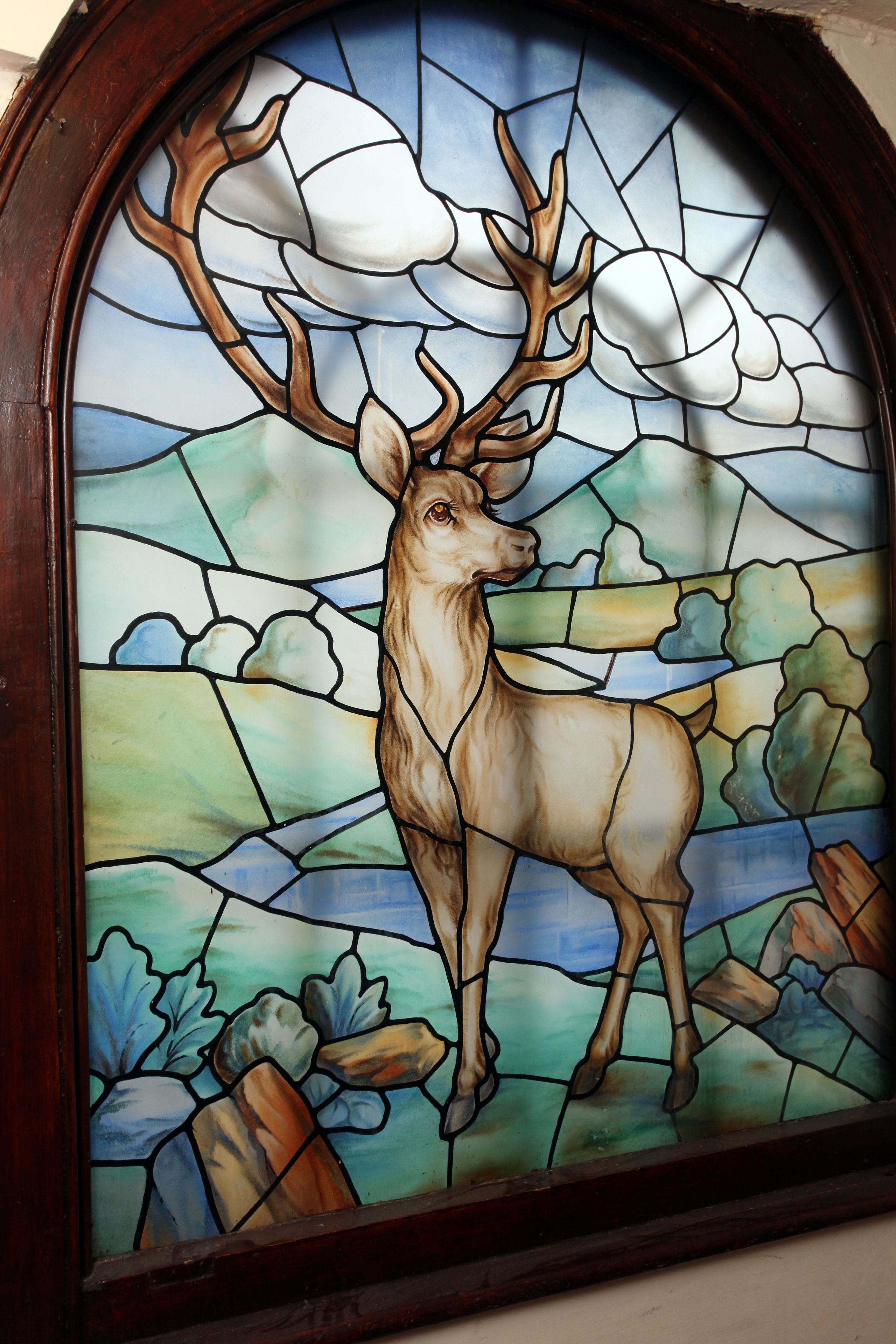 A stained glass window with a deer.