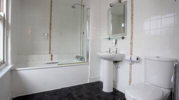 Un baño con bañera, inodoro y lavamanos.
