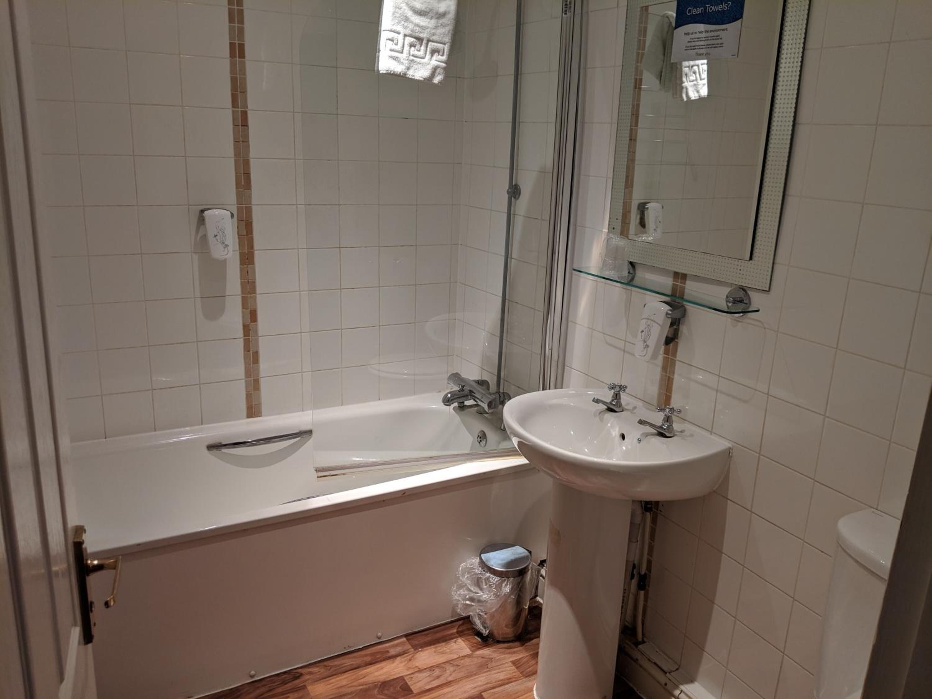 Un baño con bañera, lavamanos e inodoro.