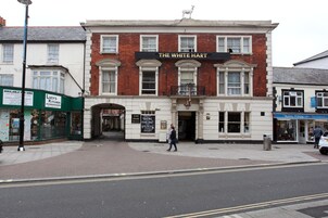 Un edificio de dos pisos con un letrero que dice "The White Hart".