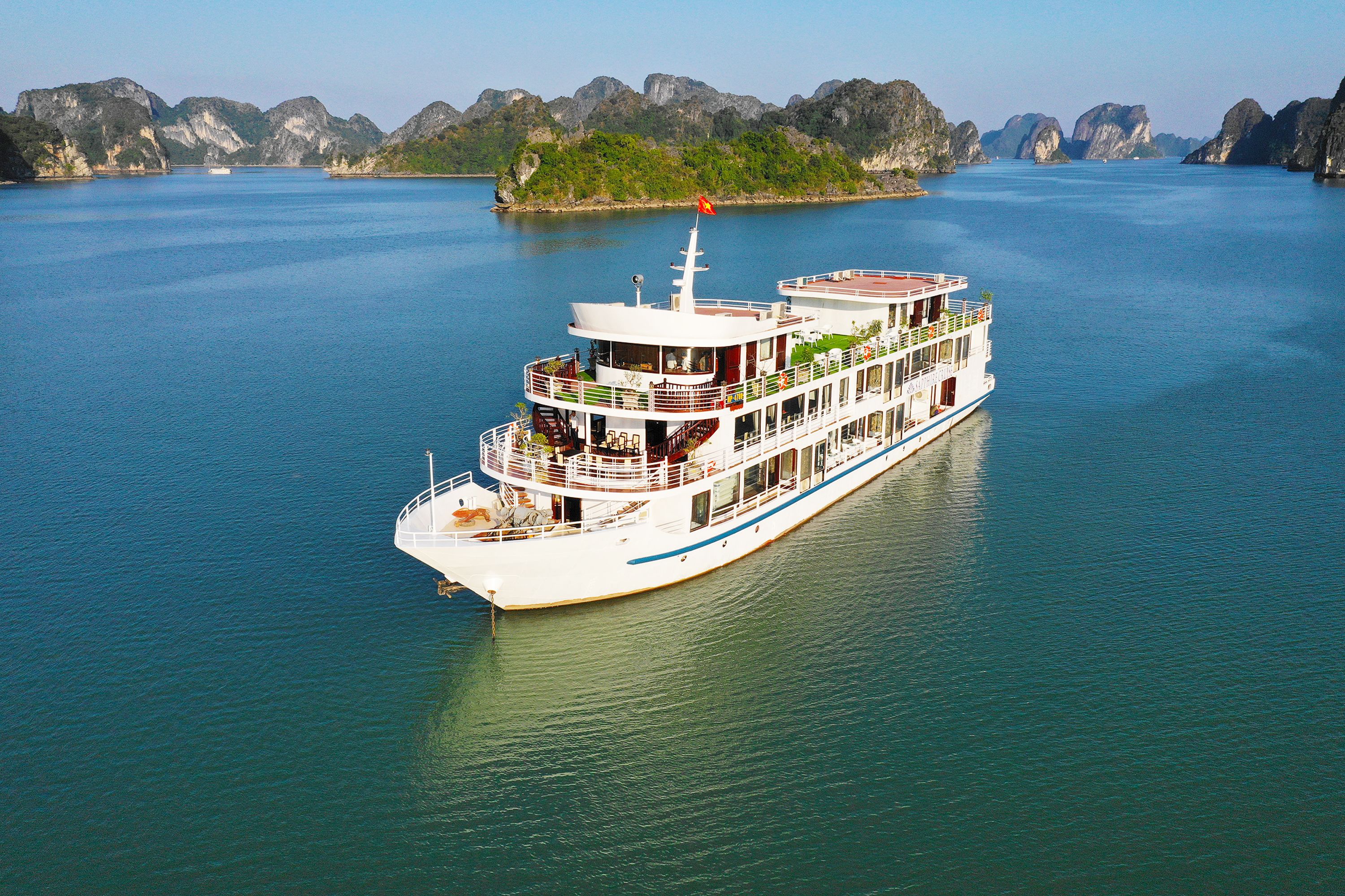 A large, multi-deck river cruise ship with multiple levels of balconies and a flag on top.