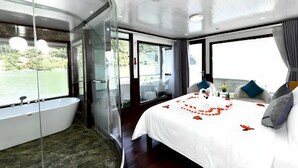 A modern bathroom with a glass-enclosed shower and a separate toilet. - Halong Sapphire Cruise (Tuan Chau)