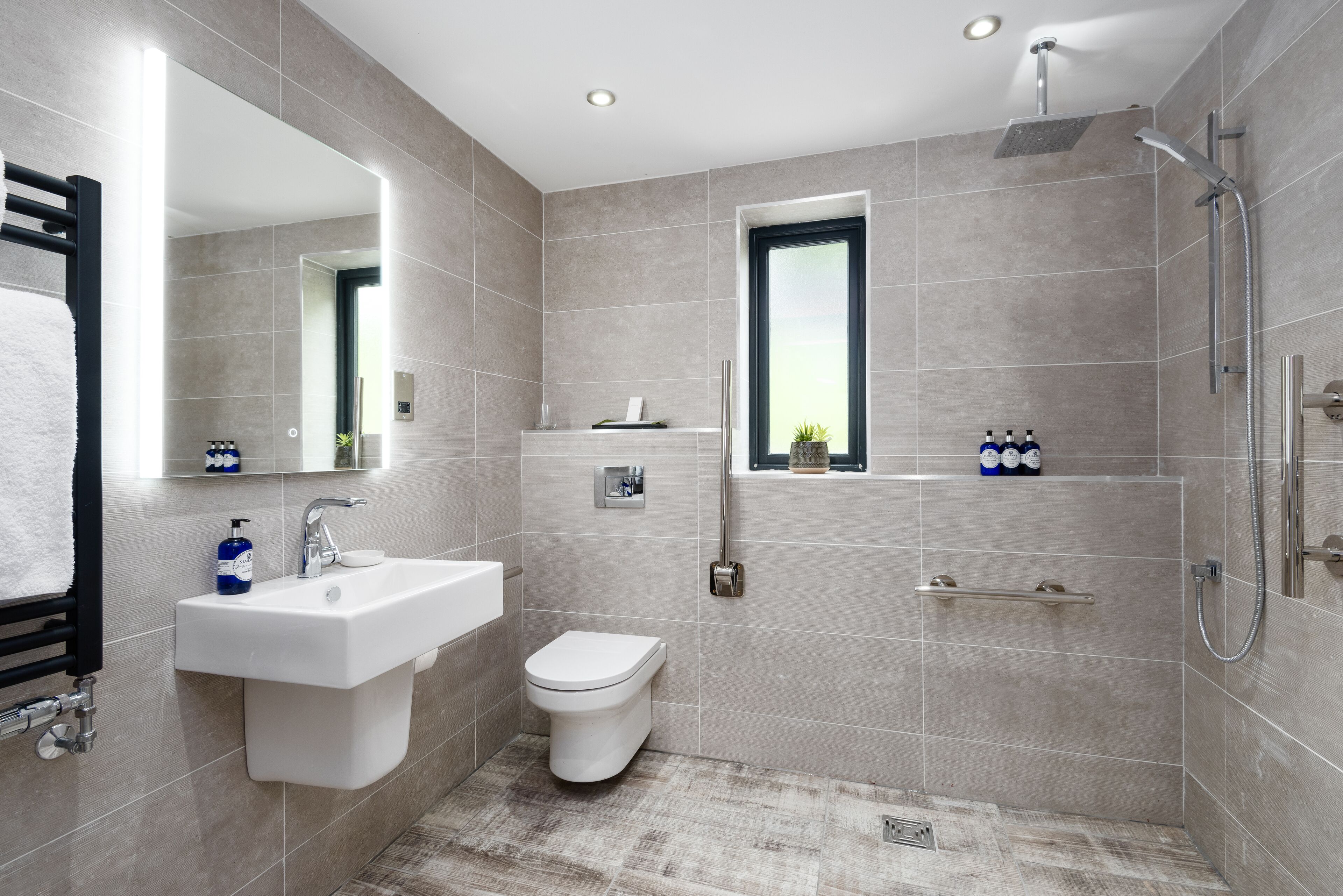 A modern bathroom with a sink, toilet, and shower.