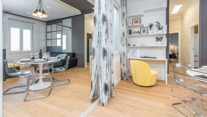 A modern interior with a dining area, a sofa, and a yellow chair. - Apartment Veduta (Zadar)