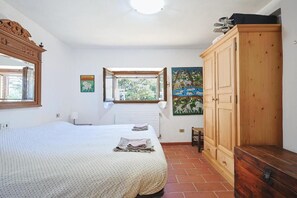 Ein Schlafzimmer mit einem Bett, einem Holzschrank, einem Fenster mit Blick und einer Heizung.