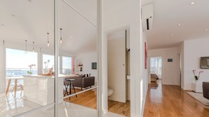 A modern living space with a kitchen, dining area, and a view of the sea. - Amazing View Apartment (Zadar)