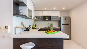Une cuisine moderne dotée d’un îlot central, d’appareils électroménagers intégrés et d’un design minimaliste.