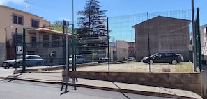 Un área de estacionamiento cercada con un letrero que indica 'P'.