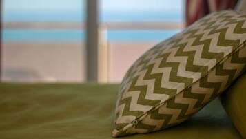 A pillow with a chevron pattern on a green bedspread.