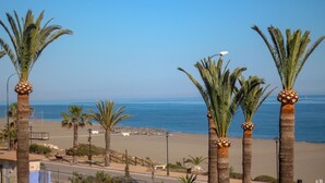A beach view with palm trees and a clear sky. - Hostal Esperanza (Velez-Malaga)