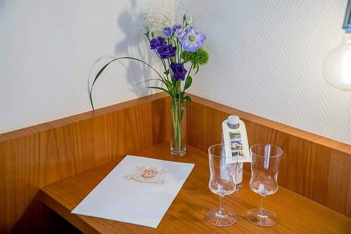 Ein Holzbüro mit Blumen, einer Speisekarte und zwei leeren Gläsern.