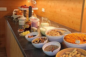 A buffet with various food items including cereals, nuts, and condiments. - Proihof (Funes)