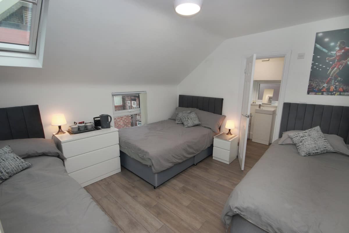 Une chambre moderne avec deux lits, un bureau et un miroir.