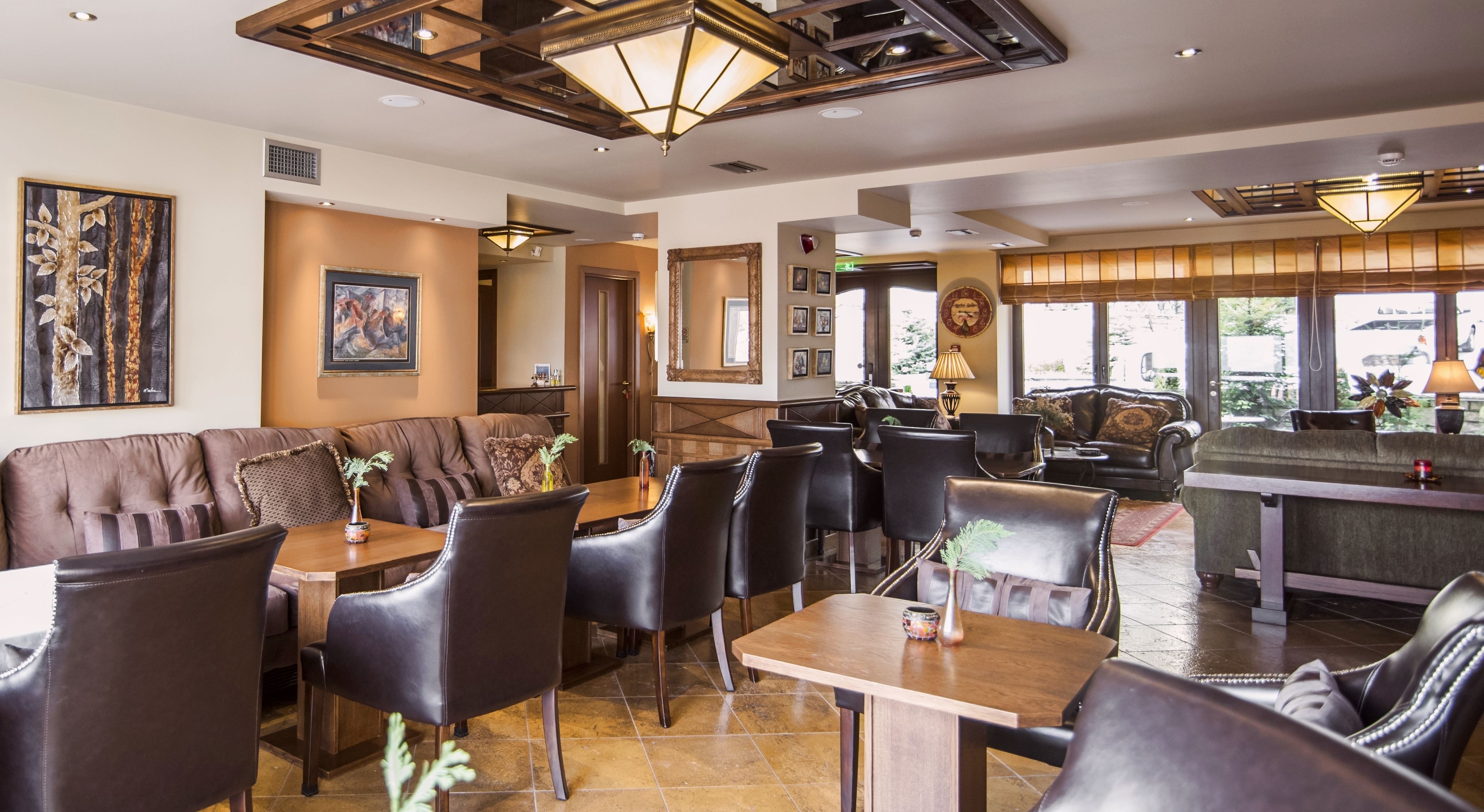 Un restaurante con asientos de cuero, mesas de madera y vistas al exterior.