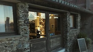 A stone building with a wooden door and windows. - Agriturismo Gocce di Luna (Celle Ligure)