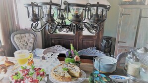 A breakfast table with pastries, a coffee pot, and a flower vase. - Agriturismo Gocce di Luna (Celle Ligure)