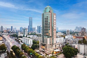 Un hôtel de grande hauteur, au design moderne, avec de nombreux étages et une entrée imposante.