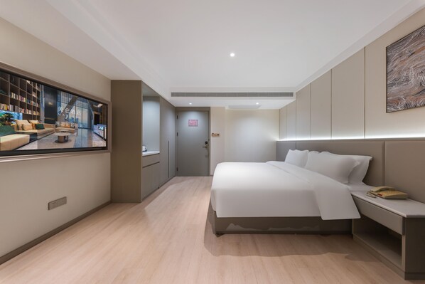 A modern hotel room with a large bed, bedside table, and a television displaying a cityscape. - Madison Hotel Hefei Ustc Port and Shipping (Hefei)