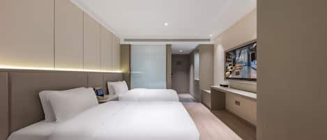 A modern hotel room with a large bed, bedside tables, a TV, and a view of the hotel lobby.