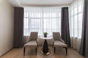 A room with two chairs, a small round table, and a potted plant.