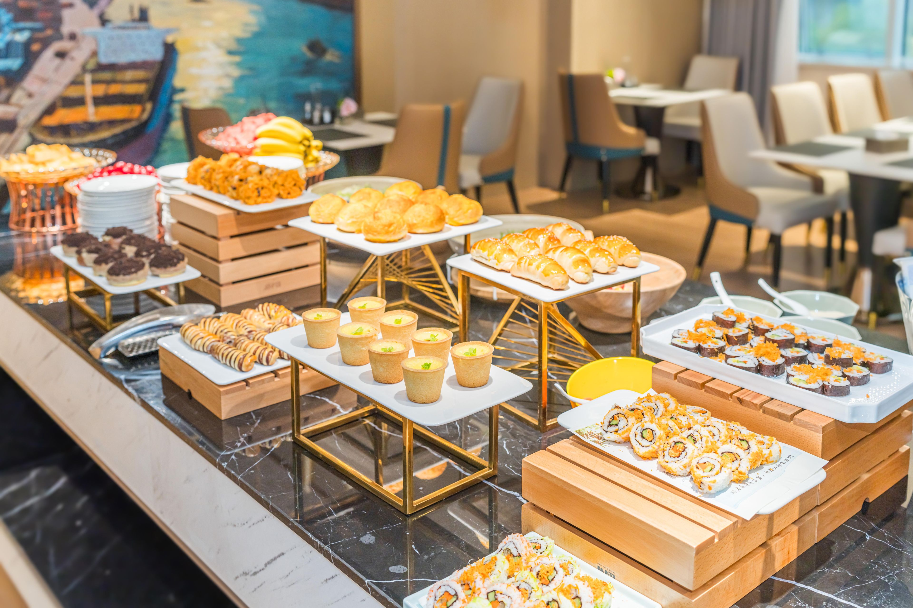 A buffet with various food items including pastries, sushi, and other dishes.