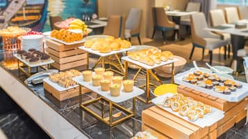 A buffet with various food items including pastries, sushi, and other dishes.