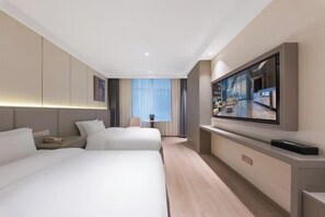 Une chambre d’hôtel avec deux lits, une télévision, un bureau et une fenêtre avec des rideaux.