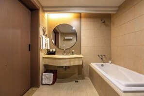 Une salle de bain moderne avec un grand miroir, un lavabo et une baignoire.