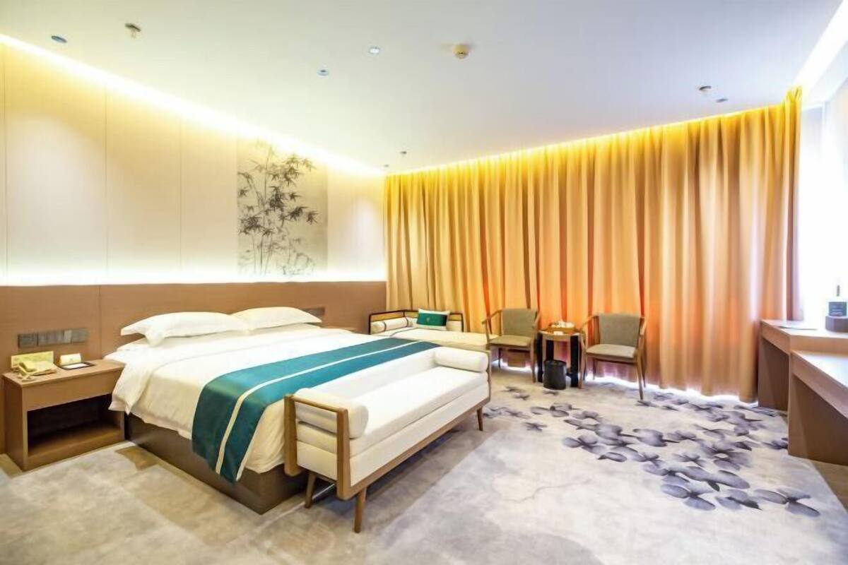 Una habitación de hotel con una cama, un escritorio, una silla y una mesita.