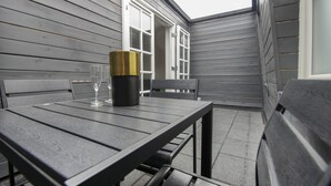 A patio with a table and chairs, a window, and a door.