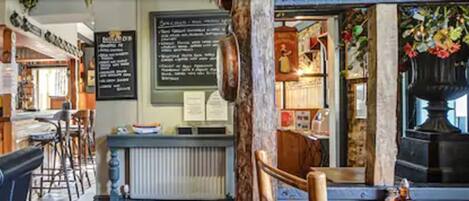 Un café acogedor con una decoración rústica, muebles de madera y un menú en la pizarra.