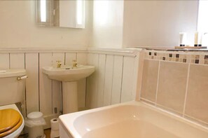 A bathroom with a toilet, sink, and bathtub.