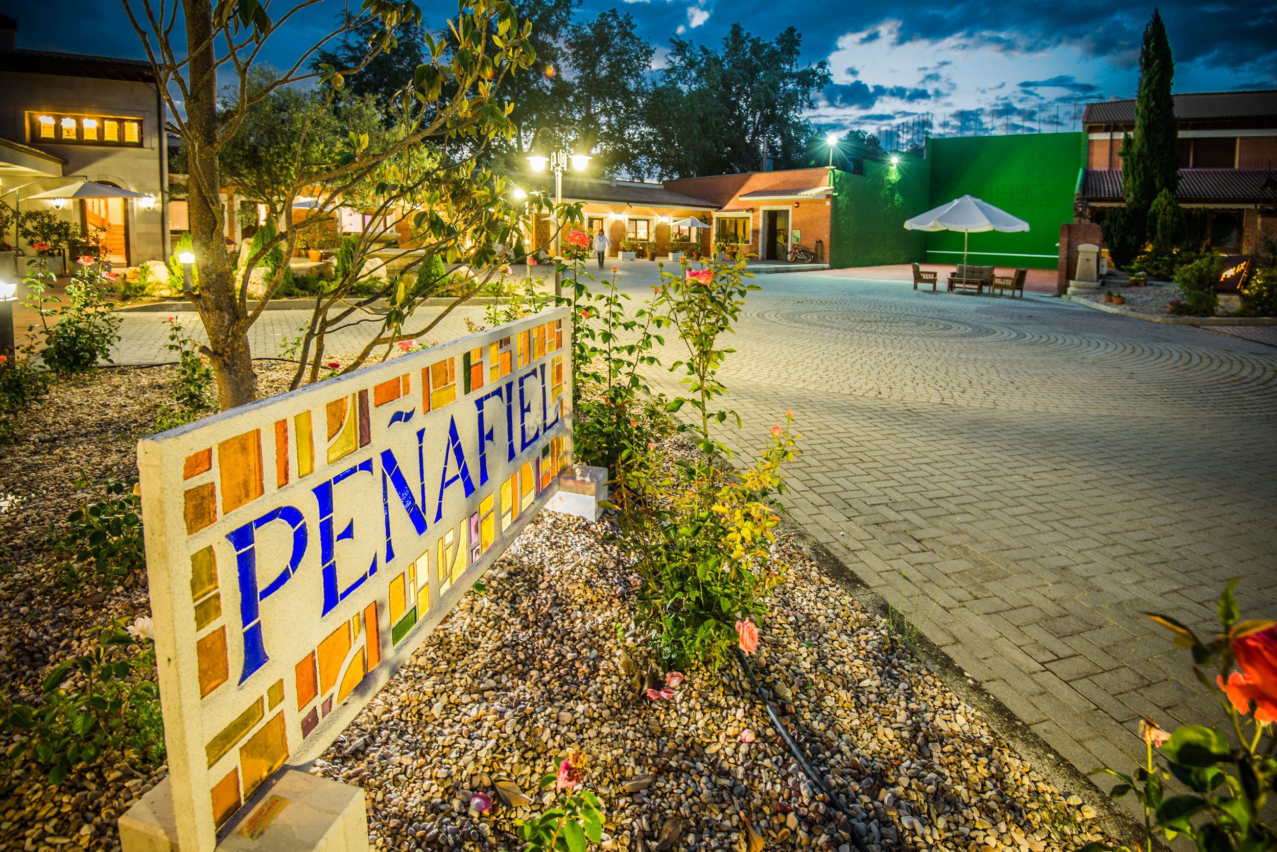 Señal del hotel PENAFEL con un patio empedrado y zona de estar al aire libre.