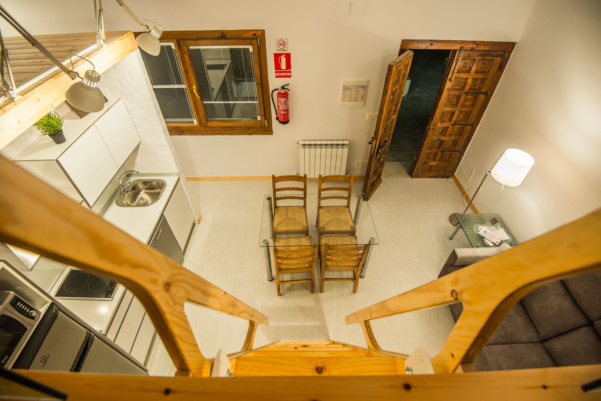 A kitchen with a window, a fire extinguisher, and a table with chairs.