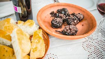 Uma mesa com um prato de terracota segurando pão e uma garrafa de vinho.