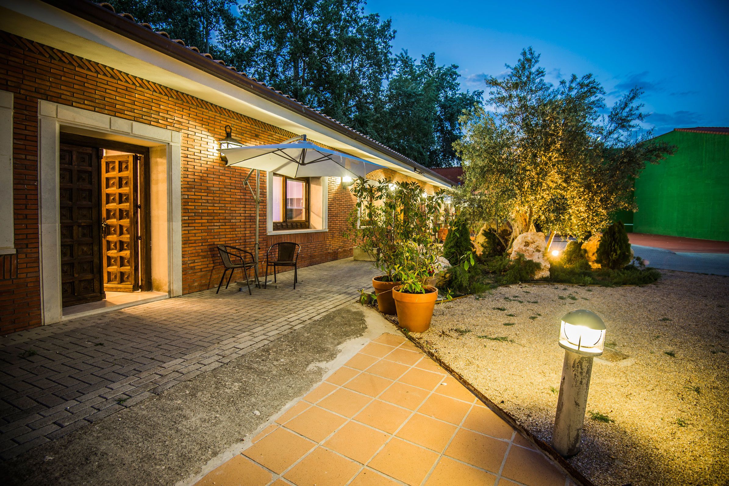 Une maison en briques avec un patio, une porte et une fenêtre.