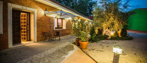 Une maison en briques avec un patio, une porte et une fenêtre.