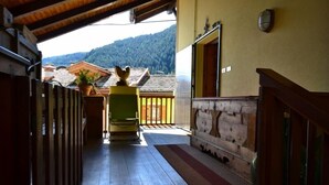 A wooden balcony with a view of a mountain.