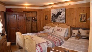 A wooden room with a bed, a desk, and a wardrobe.