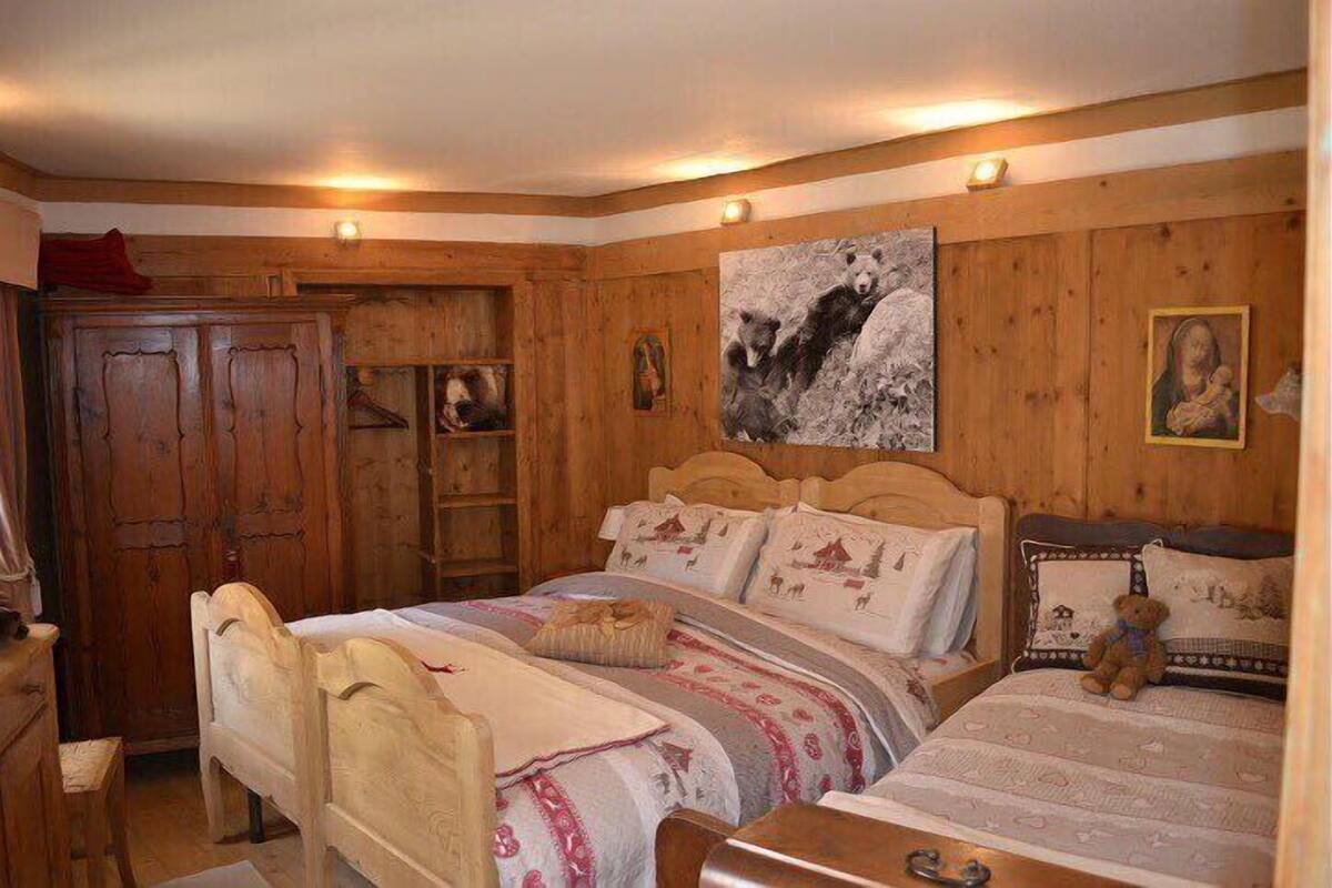 Une pièce en bois avec un lit, un bureau et une armoire.