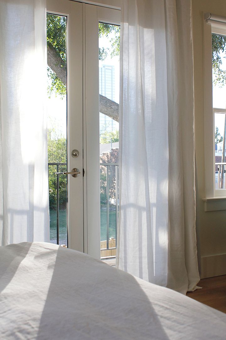Una camera da letto con un letto, una porta che dà su un balcone e una finestra.