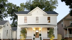 A two-story house with a front porch, a central staircase, and a brick foundation. - Guest House Raleigh (Raleigh)