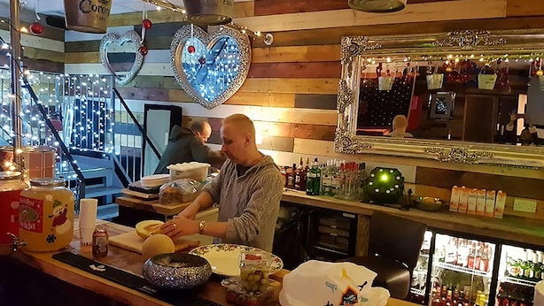 En bardisk med tillhörande sittplatser, hjärtformade dekorationer och en spegel.