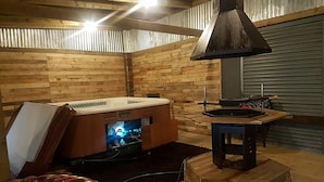 Ett mysigt rum med träinredning, en öppen spis, en tv och en bekväm sittgrupp.